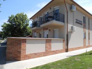 a building with two balconies on top of a brick wall at Imola és Andrea Apartmanház 2 in Hajdúszoboszló