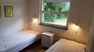 um pequeno quarto com 2 camas e uma janela em Holiday home Als em Nordborg