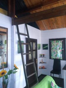 a room with a ladder and a tv and a chair at El mirador del consuelo in Jorquera