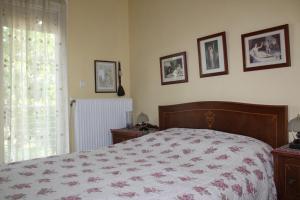 a bedroom with a bed and some pictures on the wall at Village Guesthouse in Keramoti