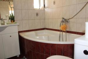 a bathroom with a tub and a toilet and a sink at Village Guesthouse in Keramoti +18 photos
