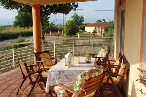 a patio with a table and chairs on a porch at Village Guesthouse in Keramoti