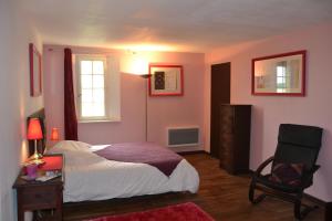 - une chambre avec un lit, un bureau et une chaise dans l'établissement Gîtes du Château de La Motte, à Usseau
