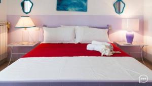 a white dog laying on top of a large bed at Le Terrazze in Otranto