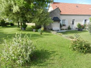 um jardim com uma casa e um quintal com plantas em Le puits de la Montrée em Chahaignes