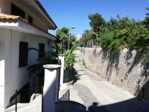 an empty street next to a white building at La Cycas Accommodation in Tropea