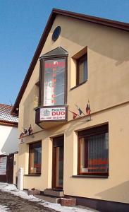 un bâtiment avec un panneau sur son côté dans l'établissement Penzion Duo, à Mladá Boleslav
