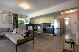 a living room with a couch and a kitchen at Erato Apartment in Tsilivi
