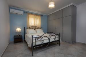 a bedroom with a bed and a blue wall at Erato Apartment in Tsilivi