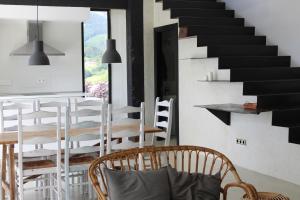 Habitación con mesa, sillas y escalera. en Casa Rural ABARAXKA- Espectaculares Vistas a las Verdes Montañas a sólo 20 minutos de la Playa", en Azcoitia