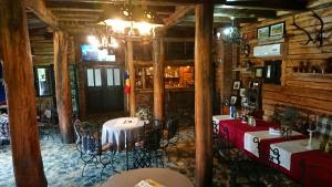 a restaurant with tables and chairs in a room with wooden walls at Satul Traditional in Runcu
