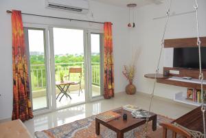 un soggiorno con una grande porta scorrevole in vetro di LE Chalet - Serviced Luxury Condominium a Ahmedabad