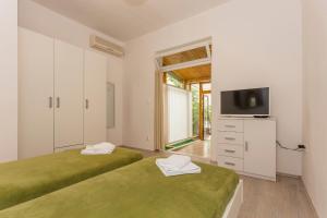 - une chambre avec 2 lits et une télévision sur une commode dans l'établissement Studio Leon-Sara, à Split