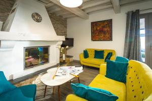 uma sala de estar com cadeiras amarelas e uma lareira em Hôtel Le Saint-Geniès em Uzès