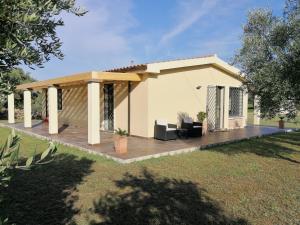 a house with a wooden deck in a yard at I due Ulivi - strada per La Caletta in Siniscola