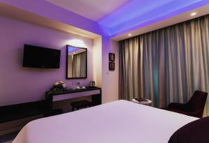 a hotel room with a white bed and a mirror at Frangiorgio Hotel in Larnaka