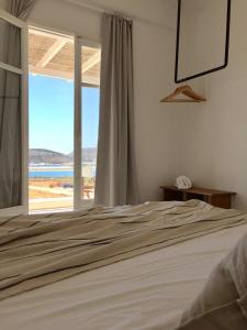 a bedroom with a bed and a view of the beach at Island White in Agios Georgios