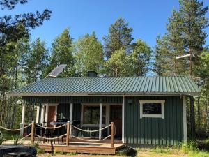 a green tiny house with a porch and a deck at ILO107 in Huhus +12 photos