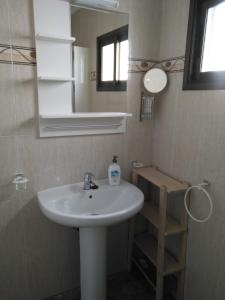 een badkamer met een witte wastafel en een spiegel bij Casa Corina. Primera línea de mar in Punta de Mujeres