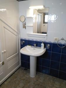une salle de bain avec un lavabo blanc et un miroir dans l'établissement Casa Corina. Primera línea de mar, à Punta de Mujeres 21 autres photos