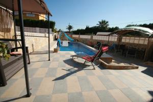 a swimming pool with a chair and a slide at Villa Brownies in Els Poblets
