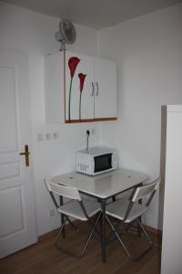 stół z kuchenką mikrofalową i 2 krzesłami w pokoju w obiekcie Studio Dijon entre fac hopital et centre w mieście Dijon