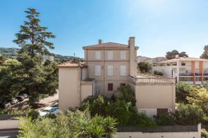 ein altes Haus auf einem Hügel mit Bäumen und Autos in der Unterkunft Cannes Centre ville in Cannes