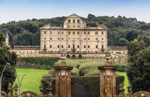 un grand bâtiment avec un jardin en face dans l'établissement B&B Al borgo, à Frascati