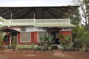 a red and white house with a balcony on it at Shilaj in Dapoli