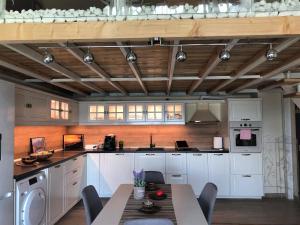 eine Küche mit weißen Schränken und einem Tisch mit Stühlen in der Unterkunft Villa Victoria - a luxury appartment with icredible Seaview in Sozopol + 34 Fotos