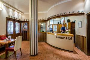 a restaurant with a man standing at a counter at Laimer Hof am Schloss Nymphenburg in Munich