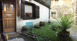 une cour avec des plantes en pot devant une maison dans l'établissement La Belette, à La Thuile