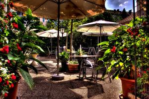 un patio con tavoli, ombrelloni e piante in vaso di Hotel Alter Telegraf a Graz