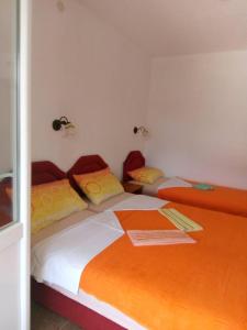 two beds in a room with orange and white at Apartmani CECA 012 Sutomore in Sutomore