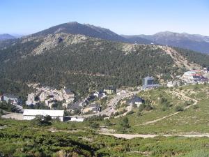 a town on a hill with mountains in the background at Apartamento Puerto de Navacerrada in Cercedilla