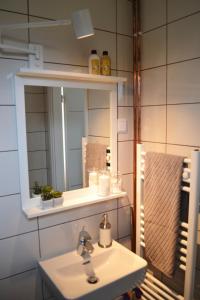 ein Bad mit einem Waschbecken und einem Spiegel in der Unterkunft Hill in Slunj