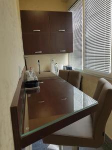 a kitchen with a glass table and chairs at Stan 110 in Orašje
