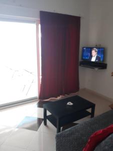 Sala de estar con cortina roja y mesa en Apartments Pehar, en Zaostrog