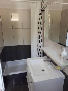a bathroom with a white sink and a bath tub at Apartments Pehar in Zaostrog