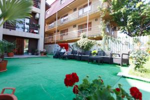 un cortile di un edificio con mobili e fiori di Vila Sandra a Costinesti