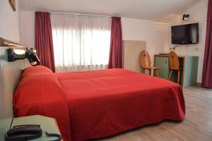 - une chambre avec un lit rouge et une couverture rouge dans l'établissement Hotel Sport, à Ledro