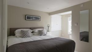 1 dormitorio con 1 cama grande y paredes blancas en Osric Apartment, en Bath