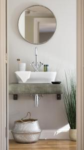 a bathroom with a sink and a mirror at Osric Apartment in Bath