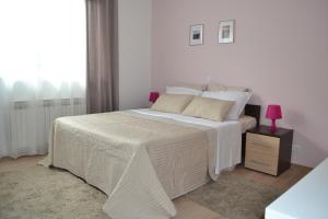ein weißes Schlafzimmer mit einem großen Bett mit einer rosa Lampe in der Unterkunft Hill in Slunj