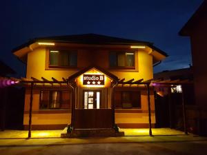 a building with a hotel sign on it at night at Studio B in Buftea