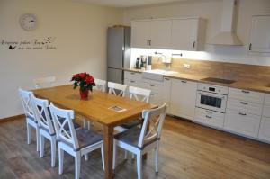 a kitchen with a wooden table and white cabinets at Spreewaldhof am Wasser in Raddusch