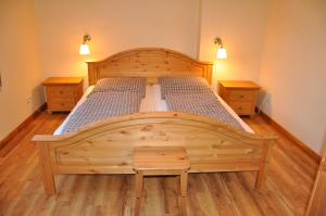 uma cama de madeira num quarto com duas mesas de cabeceira em Spreewaldhof am Wasser em Raddusch