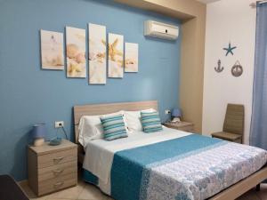 Ca&Sa Sweet Holiday في شينيسي: غرفة نوم بسرير وجدار ازرق
