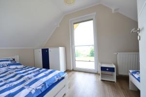 ヤストシェンビャ・グラにあるJastrzębia Marina - komfortowe całoroczne domkiのベッドルーム1室(ベッド1台、大きな窓付)
