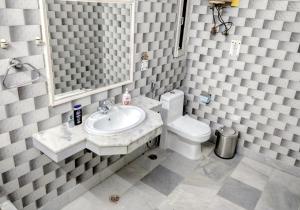 a bathroom with a sink and a toilet and a mirror at The Desire Hostel in New Delhi